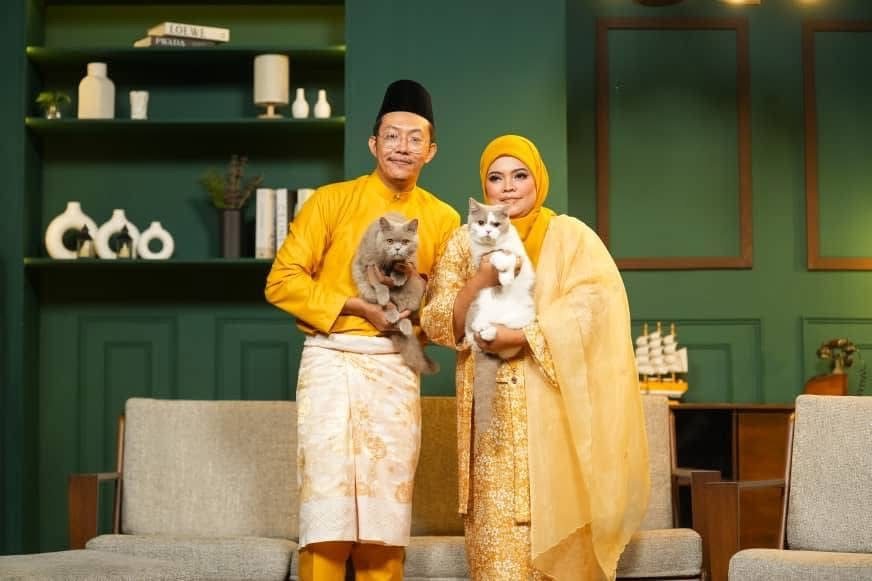 Siti and Syahmin standing with two British cats
